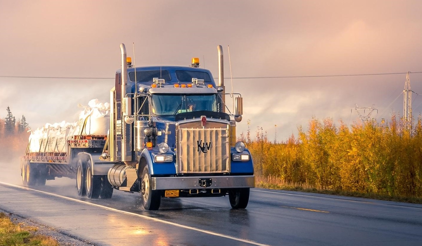 Blue flatbed truck on the road