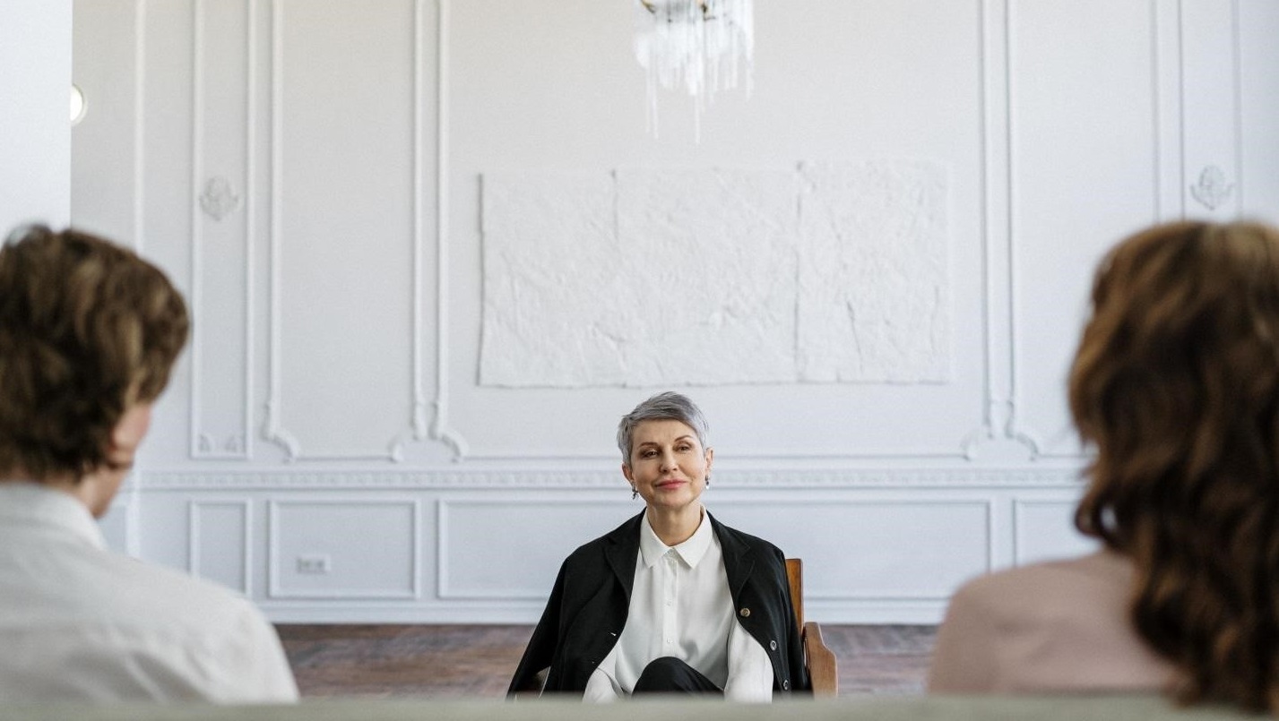 woman with a black coat listening to a couple