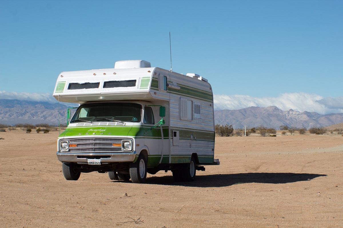 white and green rv van in the desert during day time